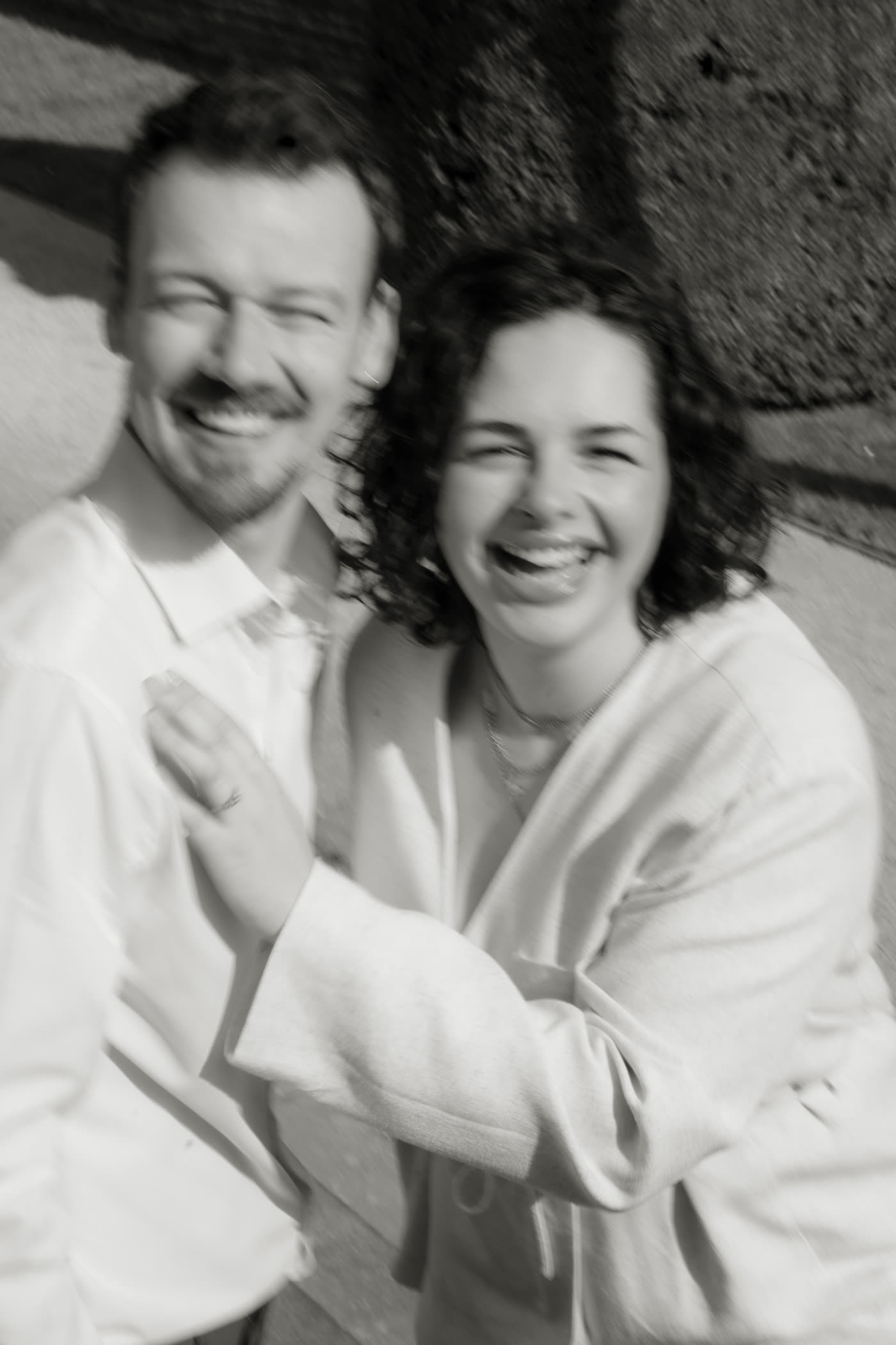 Simon et Laura éclatant de rire, en noir et blanc