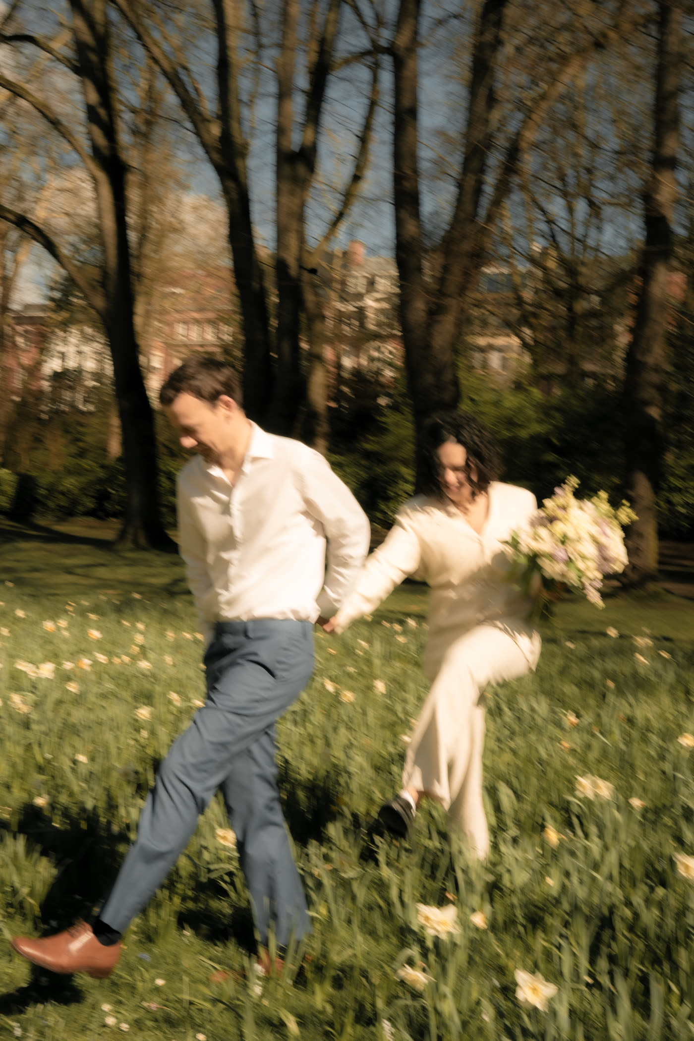 Simon en chemise blanche et pantalon bleu, Laura en ensemble crème avec un bouquet, dans l'herbe fleurie — inspiration dress code